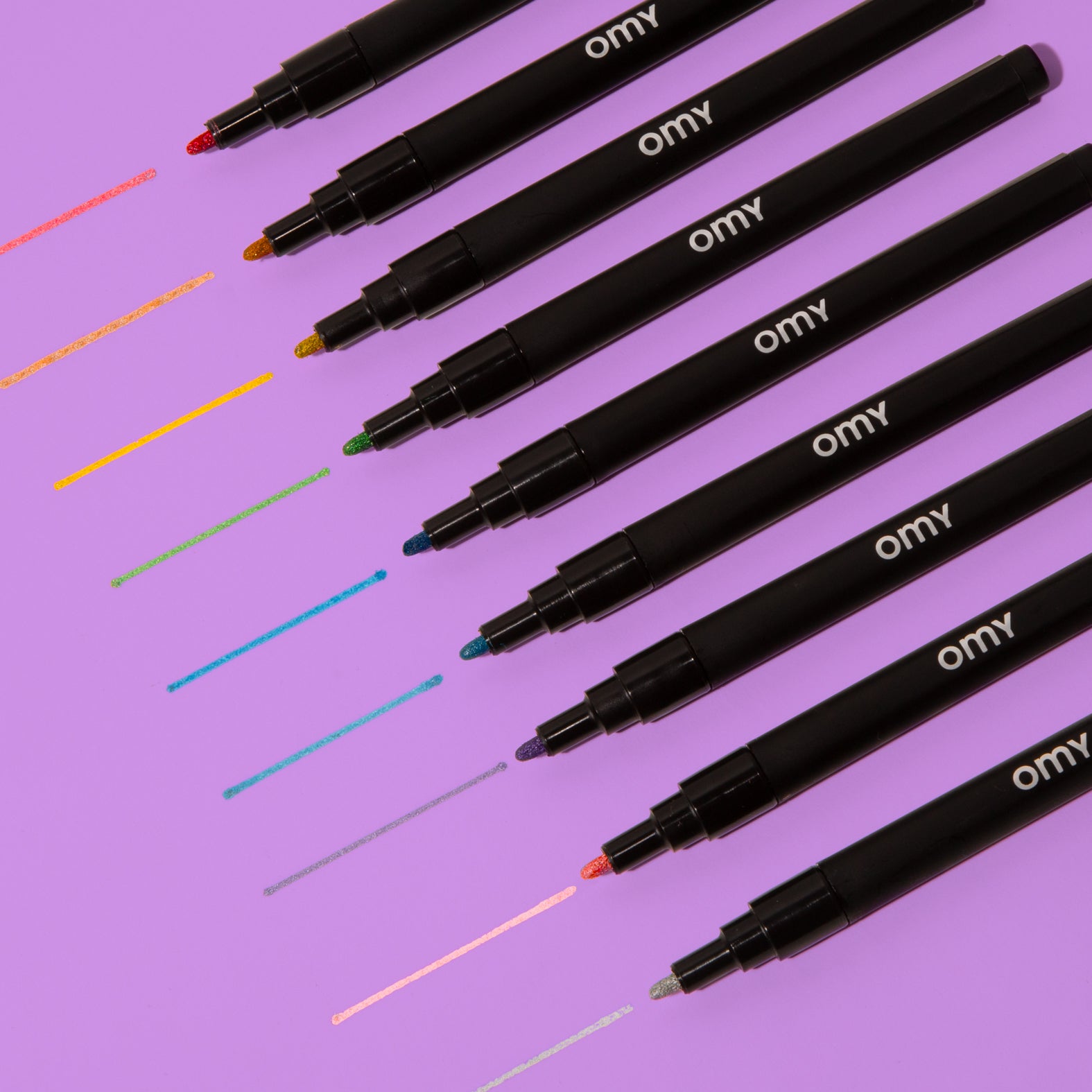 9 couleurs de feutres pailletés OMY testées sur papier violet, rendu scintillant pour supports foncés et clair, encre indélébile