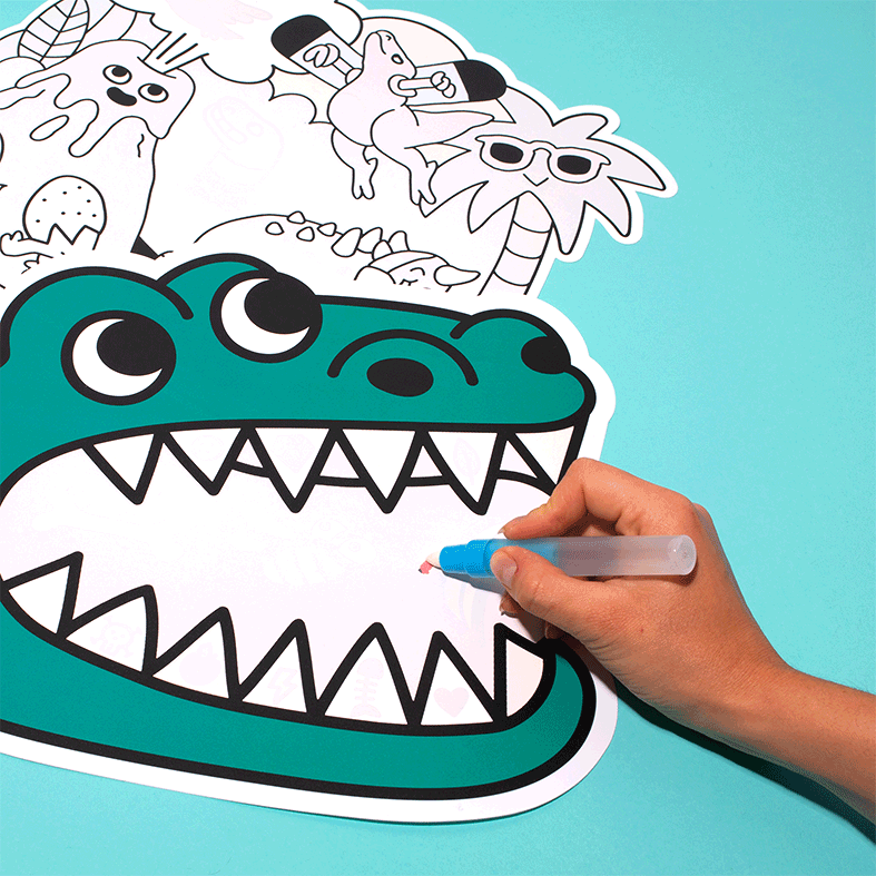 Hand fährt mit dem Wasserstift über das OMY Magic Water Dinos Tischset: Die Farben erscheinen im Maul des Dinosauriers