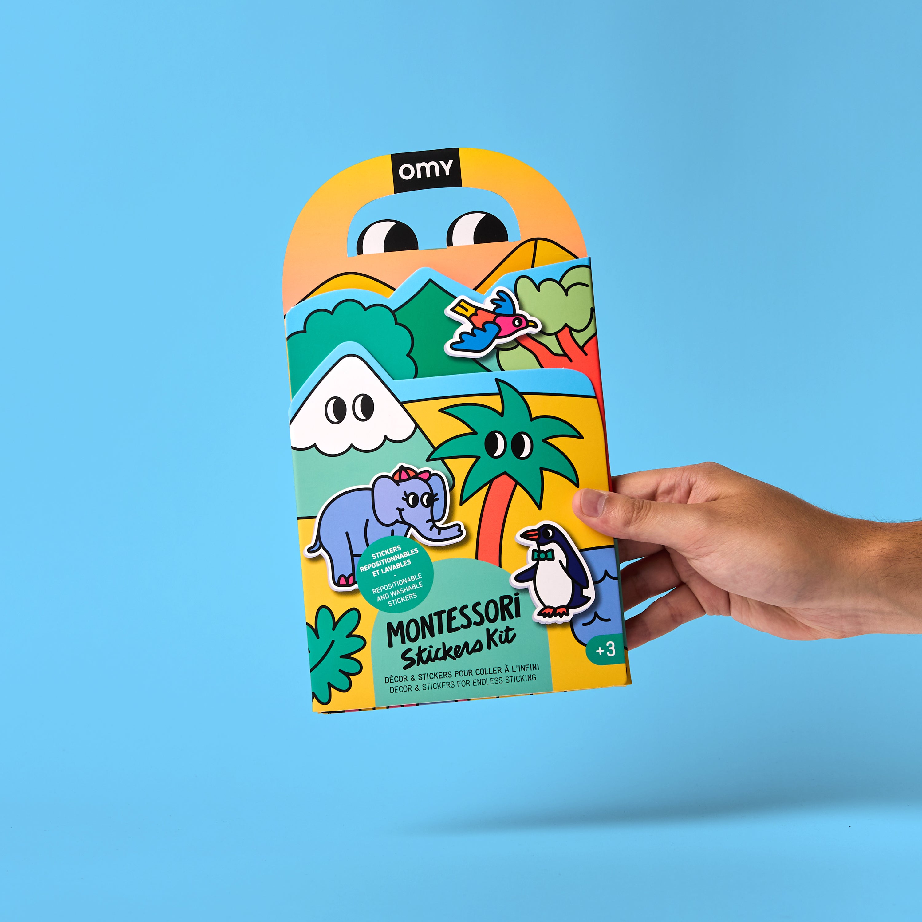 Kit Montessori Stickers Kit – Animals tenu dans une main, illustré avec des animaux rigolos sur un décor tropical coloré pour enfants dès 3 ans.