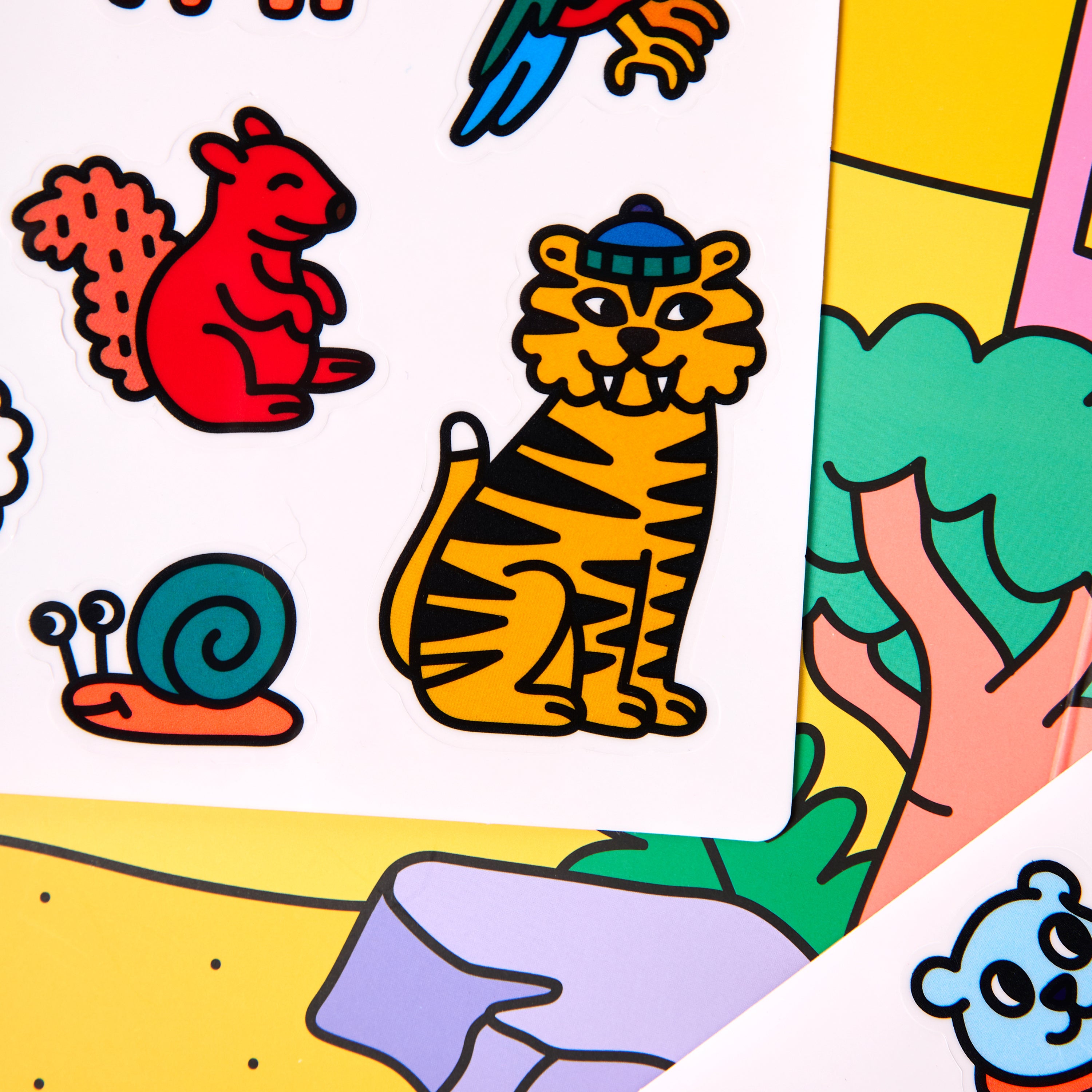 Gros plan sur les autocollants en silicone du kit Montessori Stickers – animaux : tigre, écureuil, escargot, perroquet... faciles à manipuler pour les enfants.