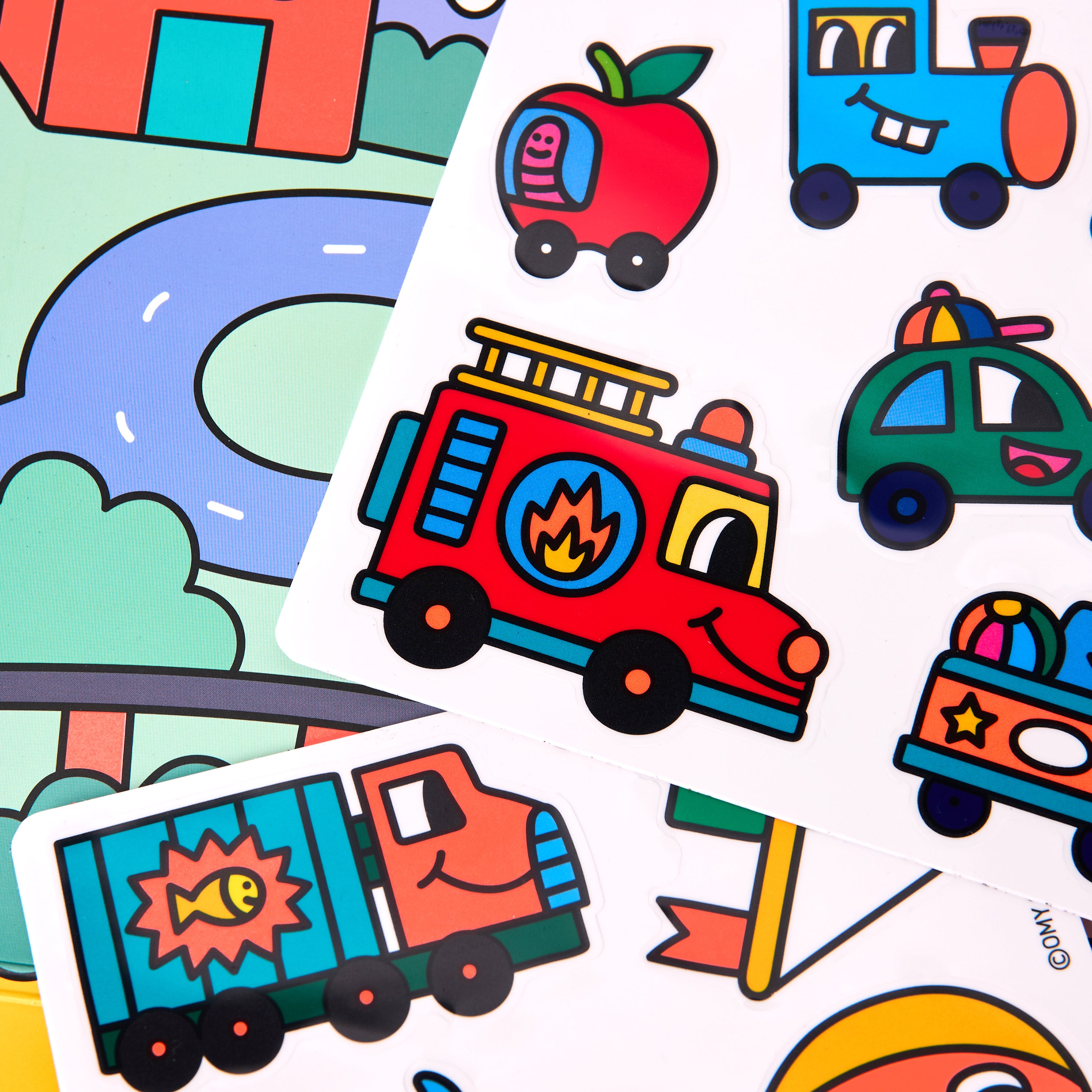 Gros plan du Kit d'autocollants Montessori - Vroom Vroom par OMY présentant des stickers en silicone repositionnables : camion de pompiers, ambulance, voiture de police et scène de ville joyeuse – activité créative réutilisable pour enfants