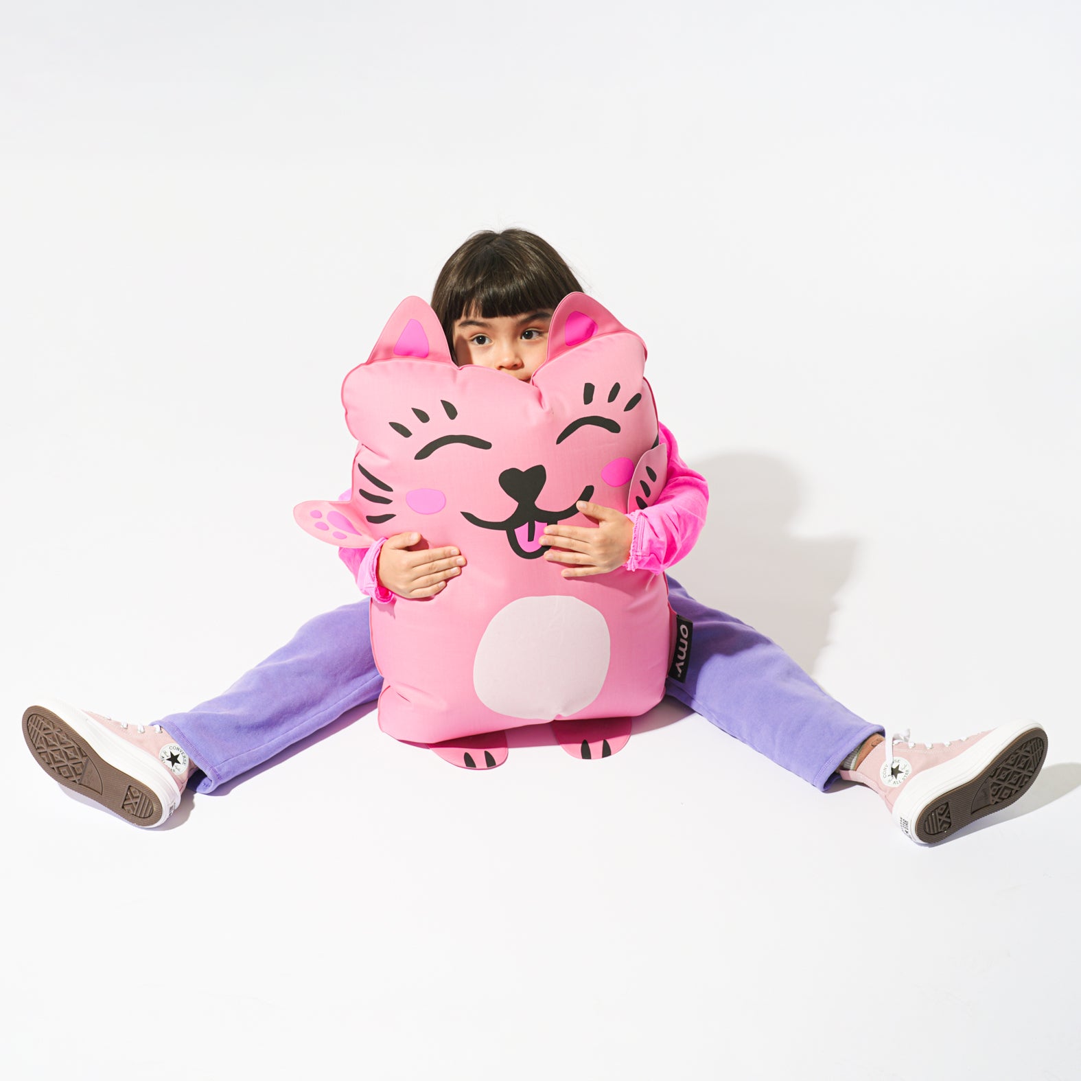 Enfant assis sur le super coussin gonflable OMY Kitty – Coussin fun et moelleux au design chat rose