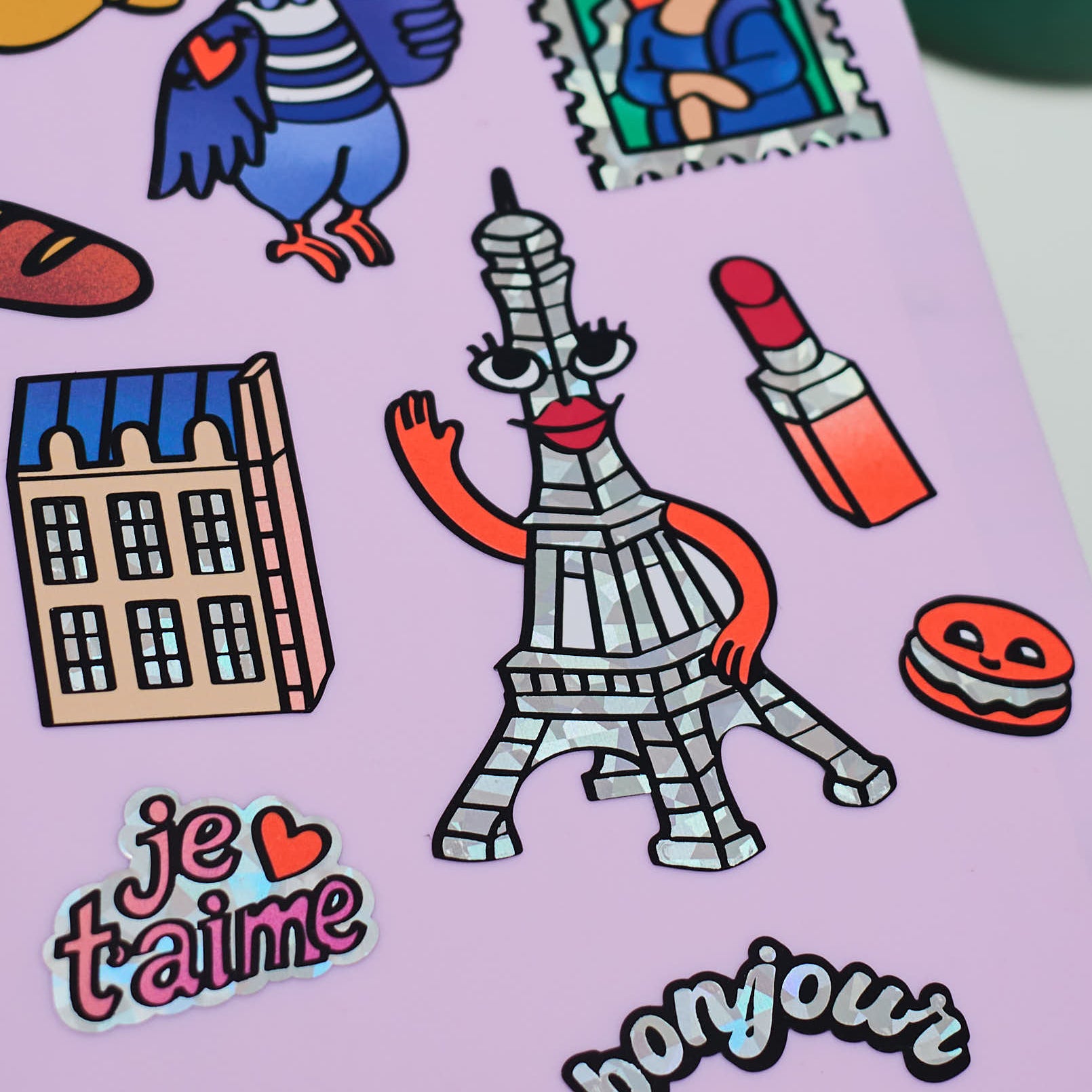 Détail sticker Tour Eiffel holographique avec visage illustré, bras et bouche rouge, issu de la collection Fabulous Stickers Paris.