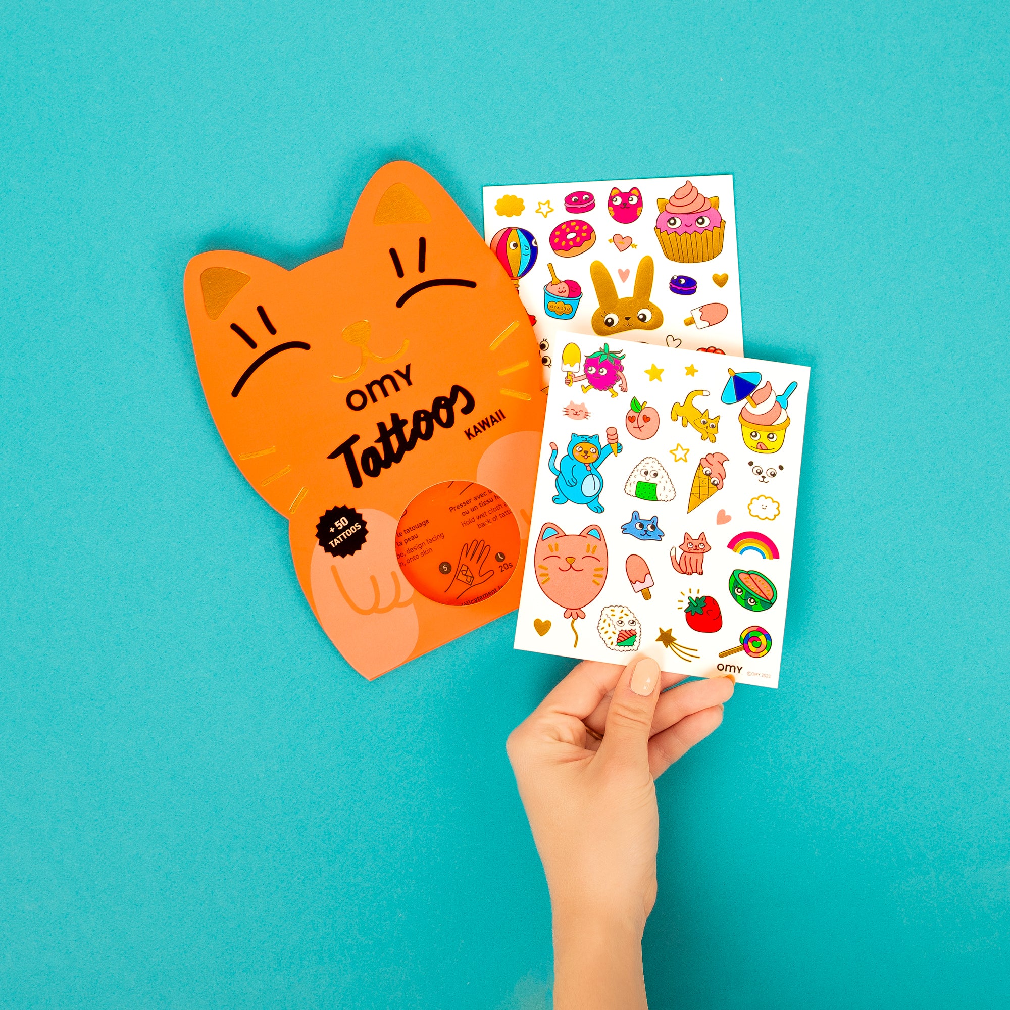 Main tenant la pochette de Tattoos Kawaii OMY – Stickers corporels pour enfant