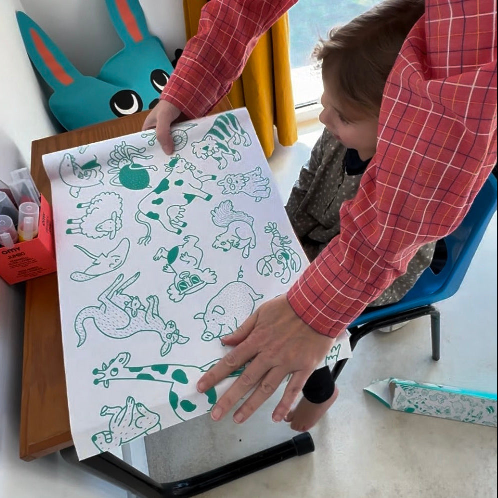 Enfant manipulant le rouleau Stick-it ANIMALS OMY, papier adhésif décoratif à colorier avec motifs d’animaux