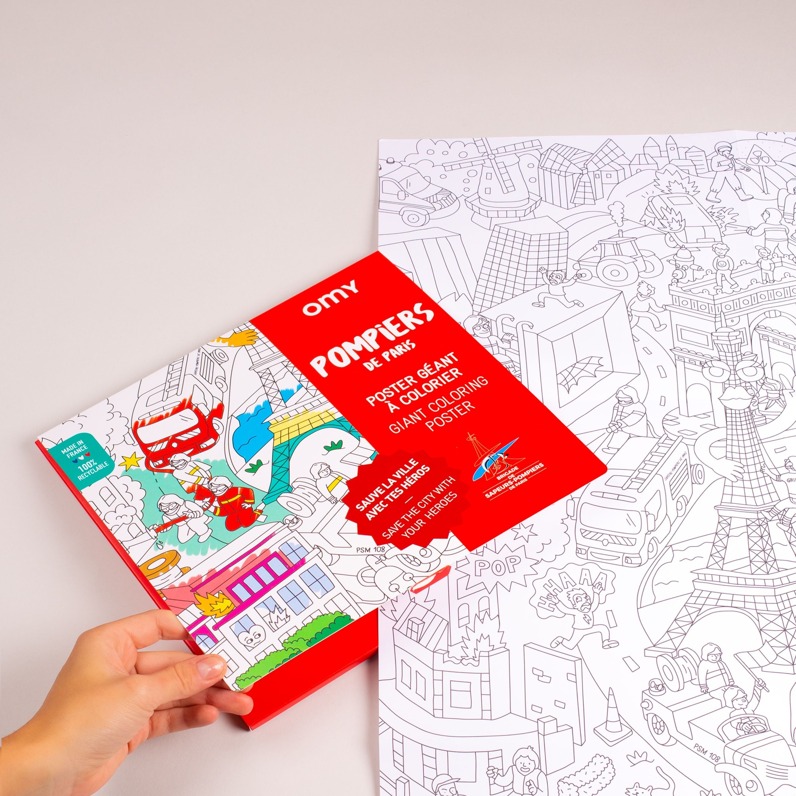 Poster géant à colorier Pompiers de Paris – visuel avec affiche partiellement dépliée et couverture rouge