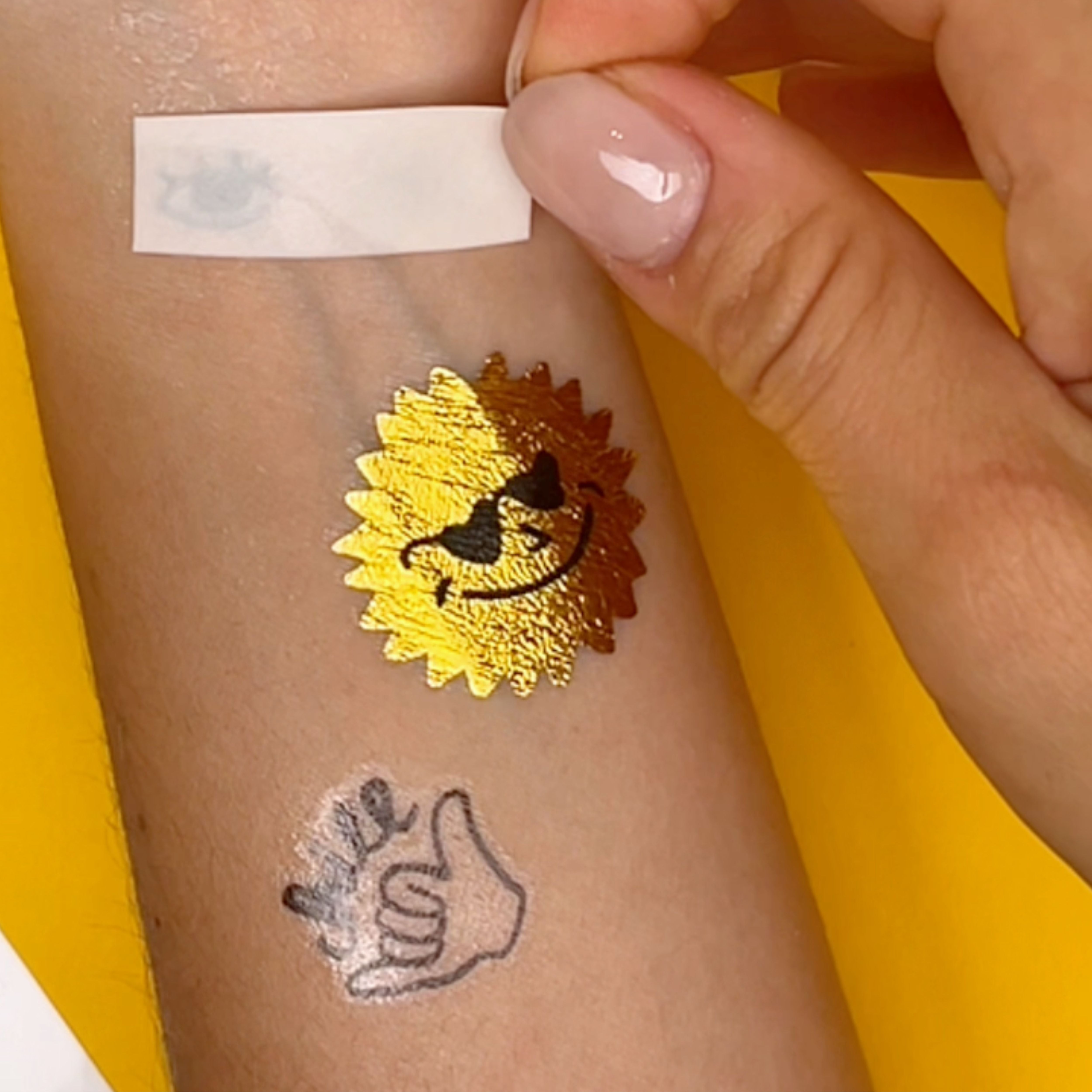 Tatouage temporaire soleil OMY Surf & Skate appliqué sur bras enfant – Design cool et fun