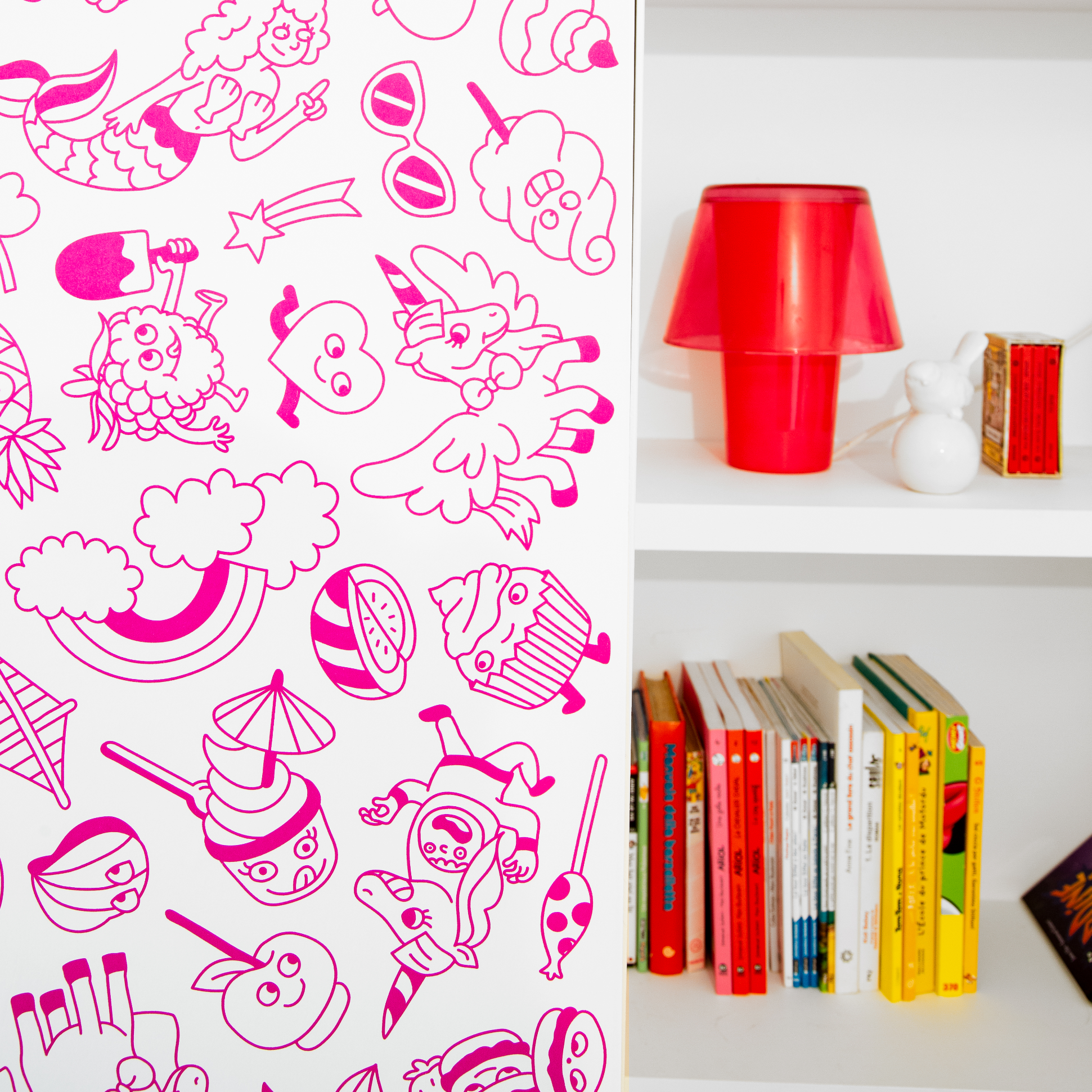 Décoration murale repositionnable OMY Stick-it Dreamland appliquée verticalement sur un meuble blanc, avec motifs arc-en-ciel, licornes et sucreries.