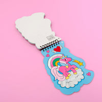 Carnet d'activités stickers Lily OMY ouvert sur une licorne rose décorée de stickers holographiques, arc-en-ciel et cœurs, sur fond rose