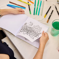 Kleurboek Cozy Art Paris opengeslagen op een uitscheurbare pagina met iconische elementen van Parijs, omringd door gekleurde stiften