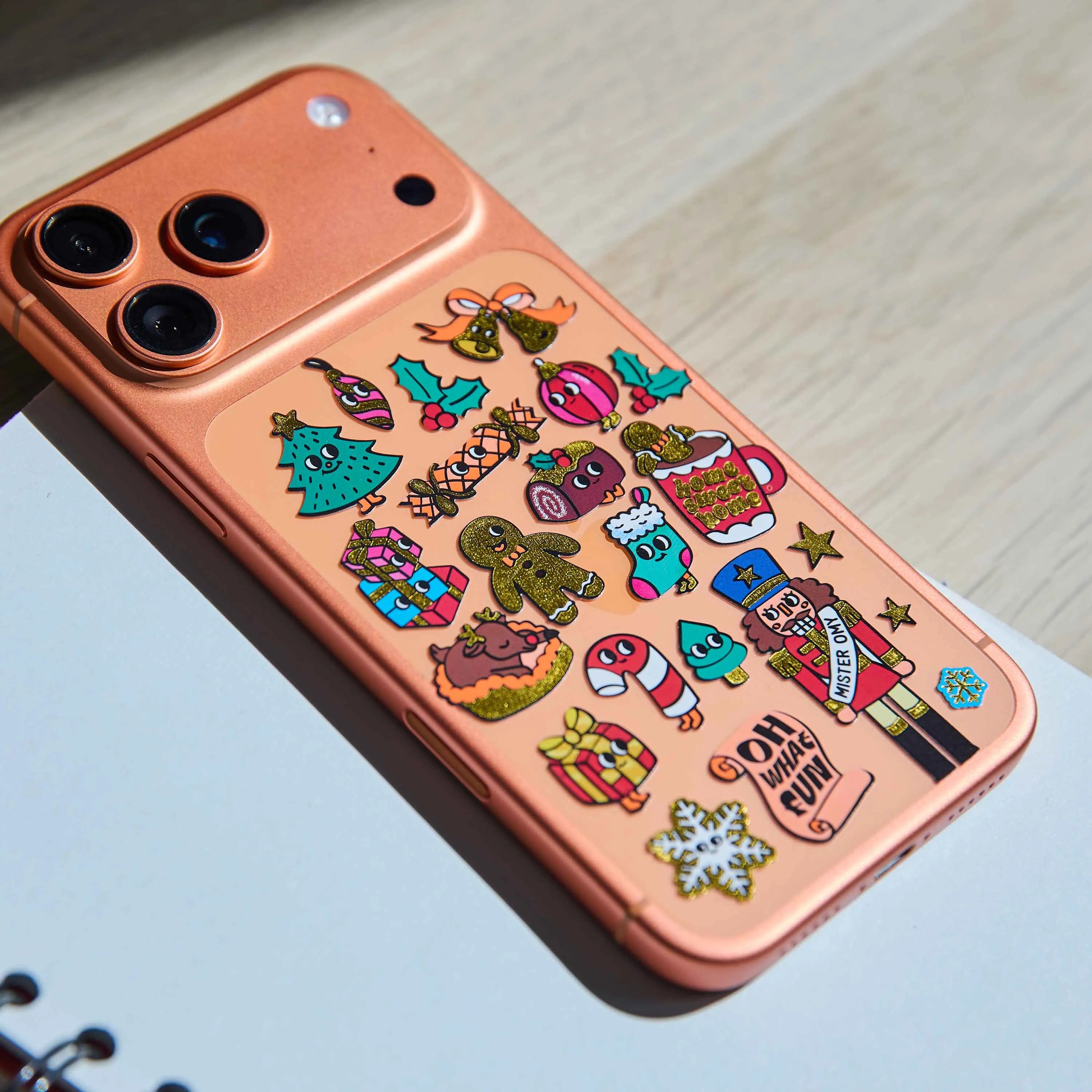 Coque de téléphone décorée avec les Fabulous Stickers Noël OMY aux motifs de sapin, casse-noisette, cadeaux et gourmandises.