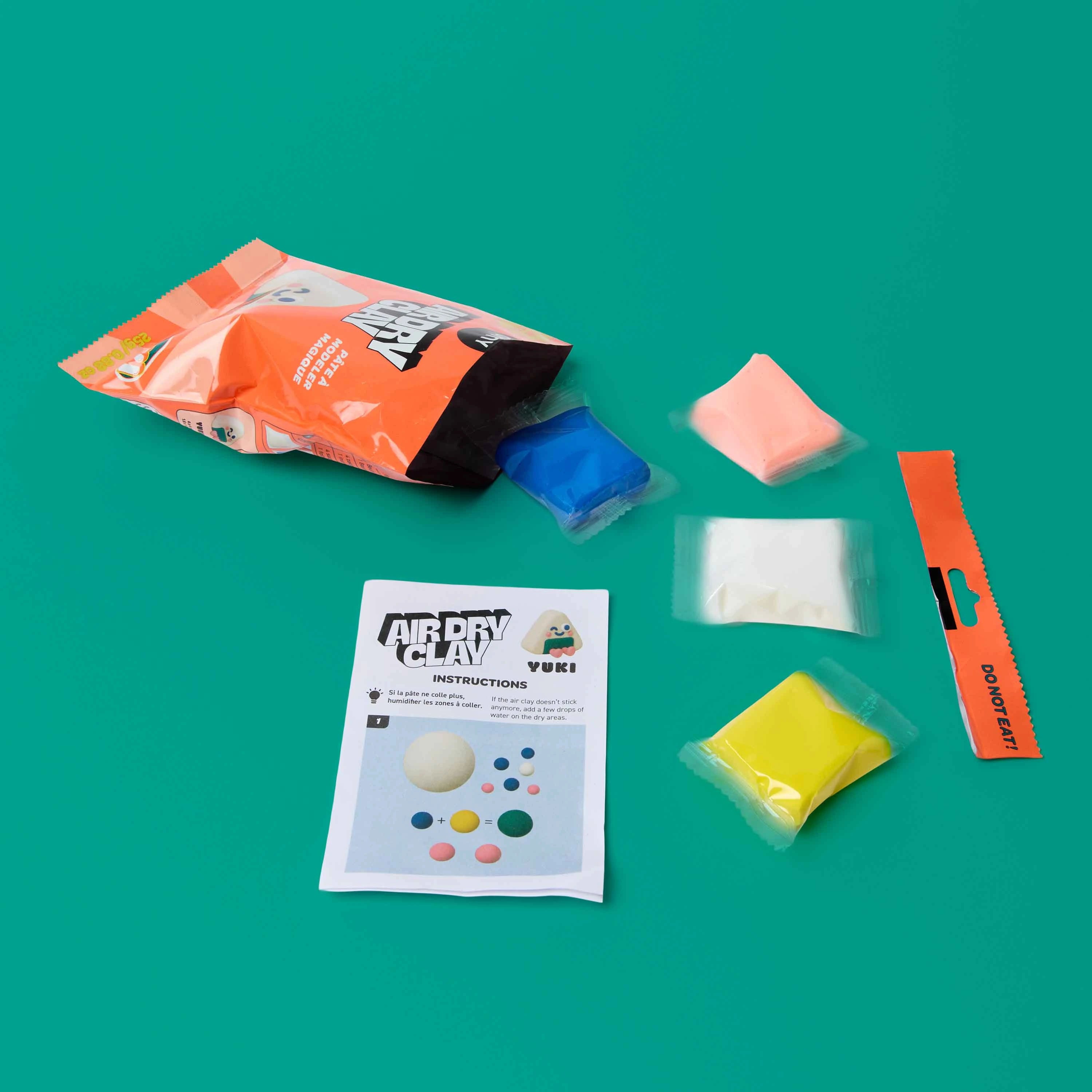 Inhalt des OMY Air Dry Clay Yuki Sets mit vier Farben Modelliermasse und Anleitungskarte