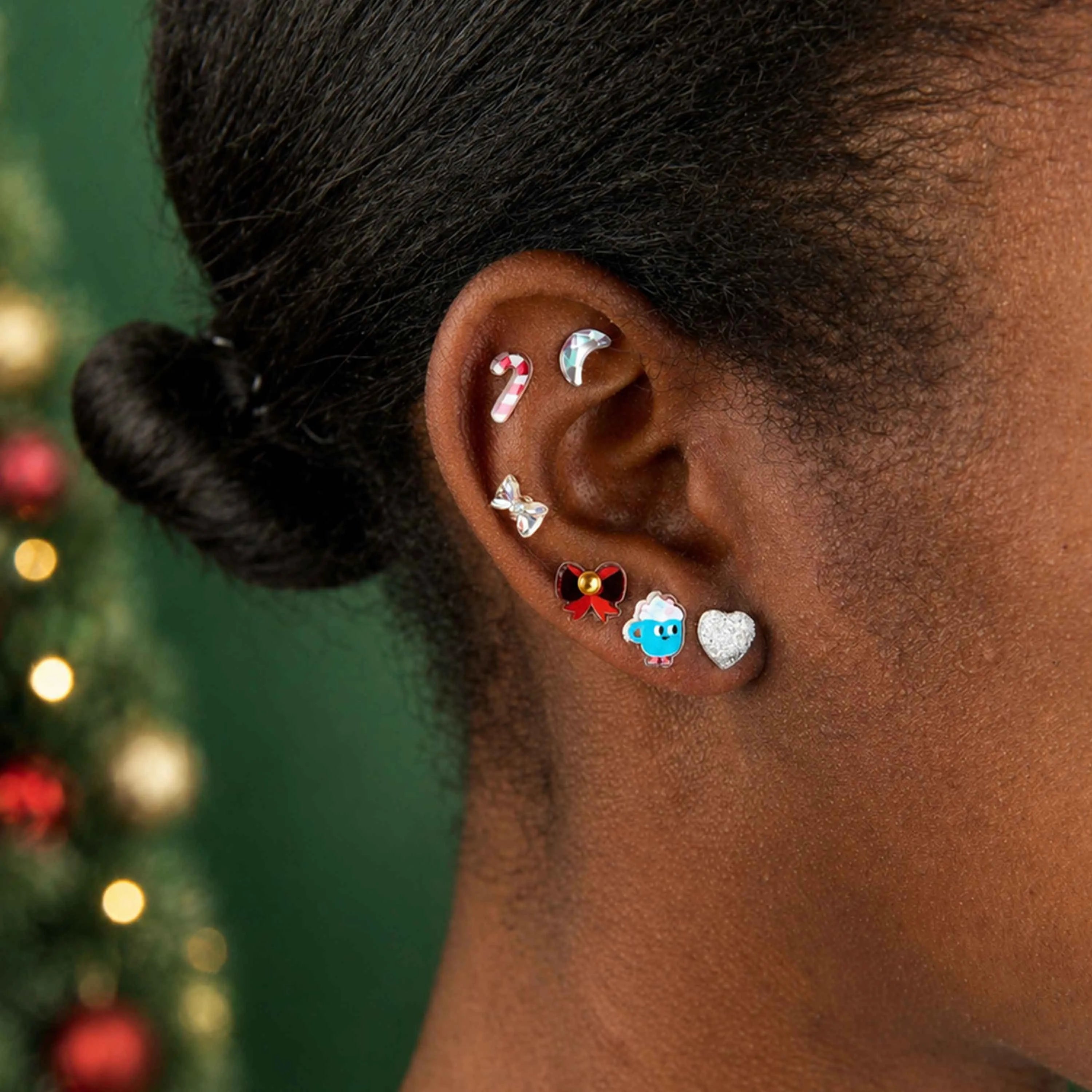 Ohr, dekoriert mit OMY Sticker-Schmuck in weihnachtlichen Motiven: Zuckerstange, Mond, Schleife und Herz.