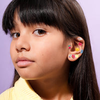 Child showing ears decorated with OMY Kawaii Earring sticker jewelry
