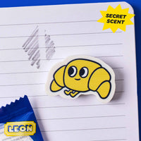 Duftradiergummi für Kinder, Croissant Leon OMY auf einem Heft mit Secret-Scent-Effekt