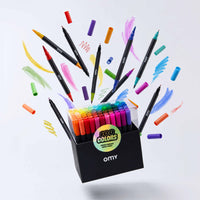 Creative scene of the OMY box of 100 double-tip markers, surrounded by markers and multicolored strokes.