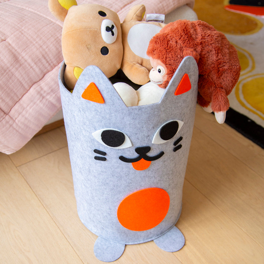 Tidy Bag Kitty OMY, panier de rangement en feutrine grise en forme de chat rempli de peluches, dans une chambre d'enfant