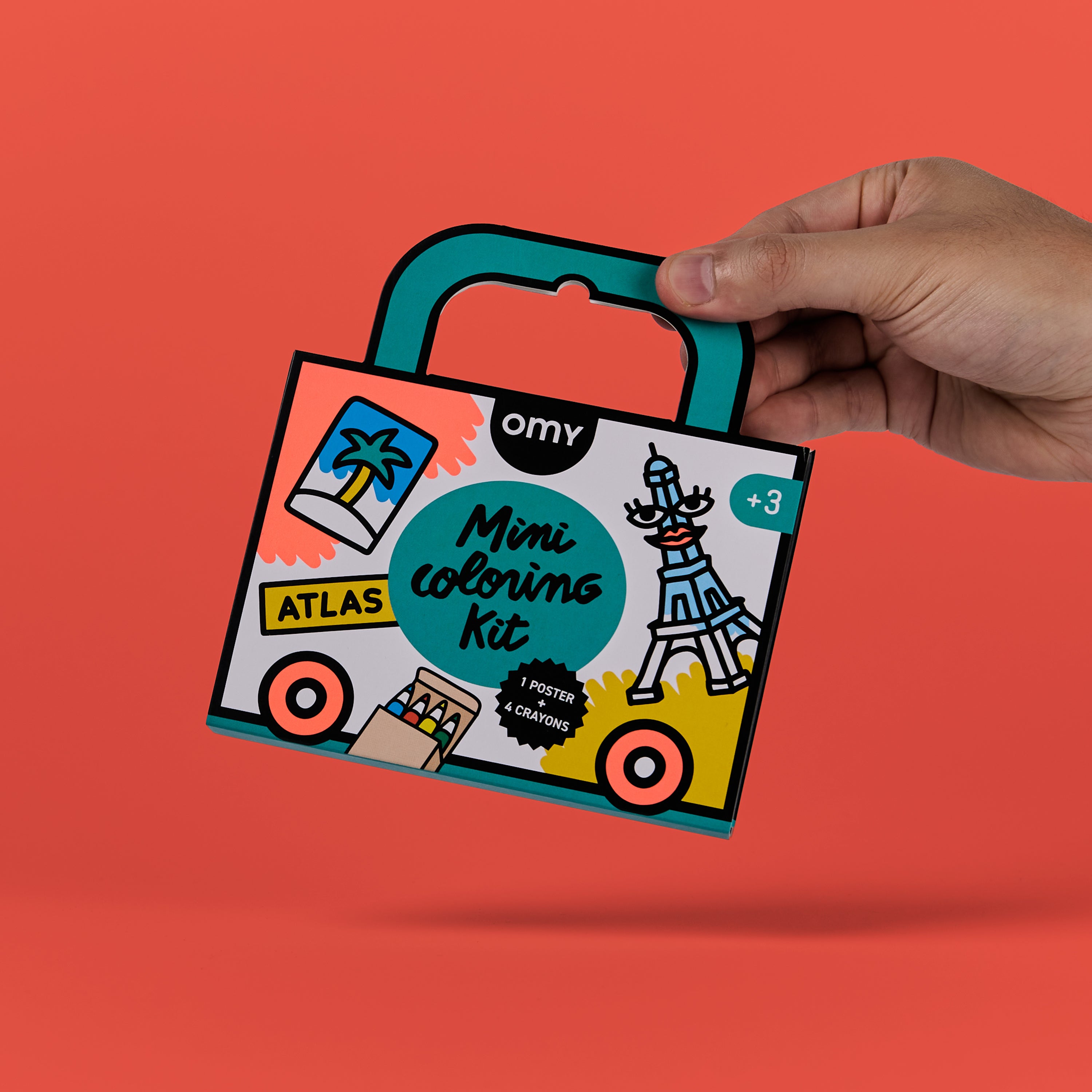 Mano sosteniendo el Mini Coloring Kit Atlas de OMY, kit de colorear portátil con asa rígida, ideal para niños a partir de 3 años