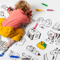 Child coloring a large poster on the floor, a creative activity ideal from 18 months with markers or finger paint