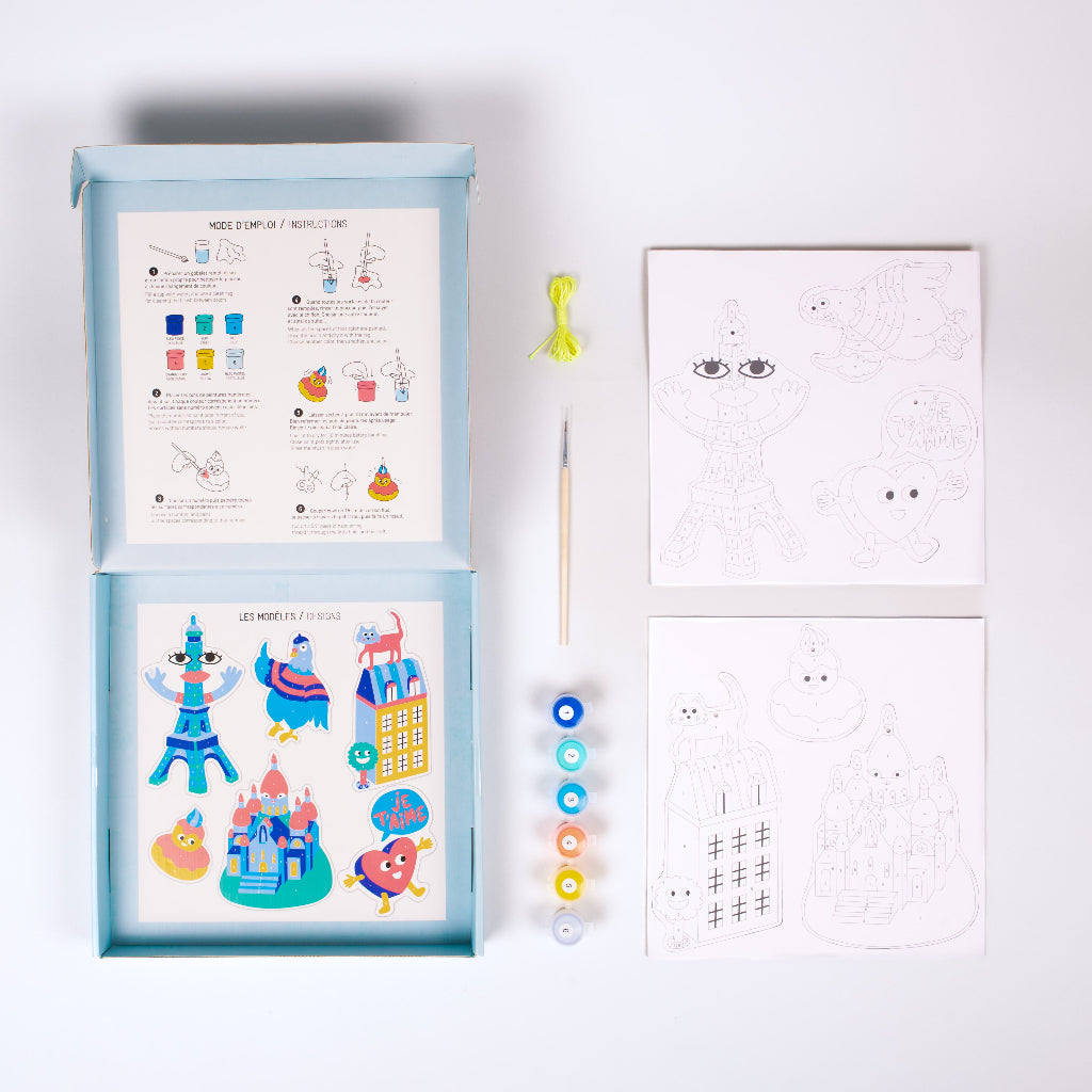 Contenu du kit OMY décorations Paris à peindre : boîte avec mode d'emploi, planches à découper, pinceau, fil et 6 peintures