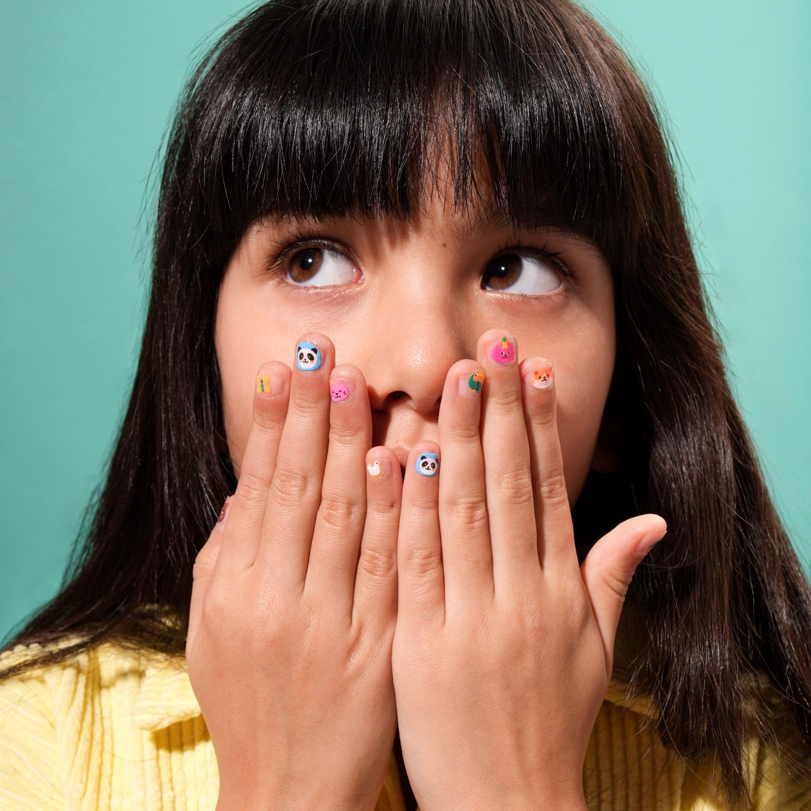 Bambina che mostra gli sticker per unghie OMY Friends, gommette creative per nail art dei bambini