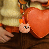 Mini peluche porte-clés Mewchi accrochée à un sac orange