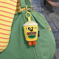 Noo Mini-Plüsch-Schlüsselanhänger an einer grünen Tasche
