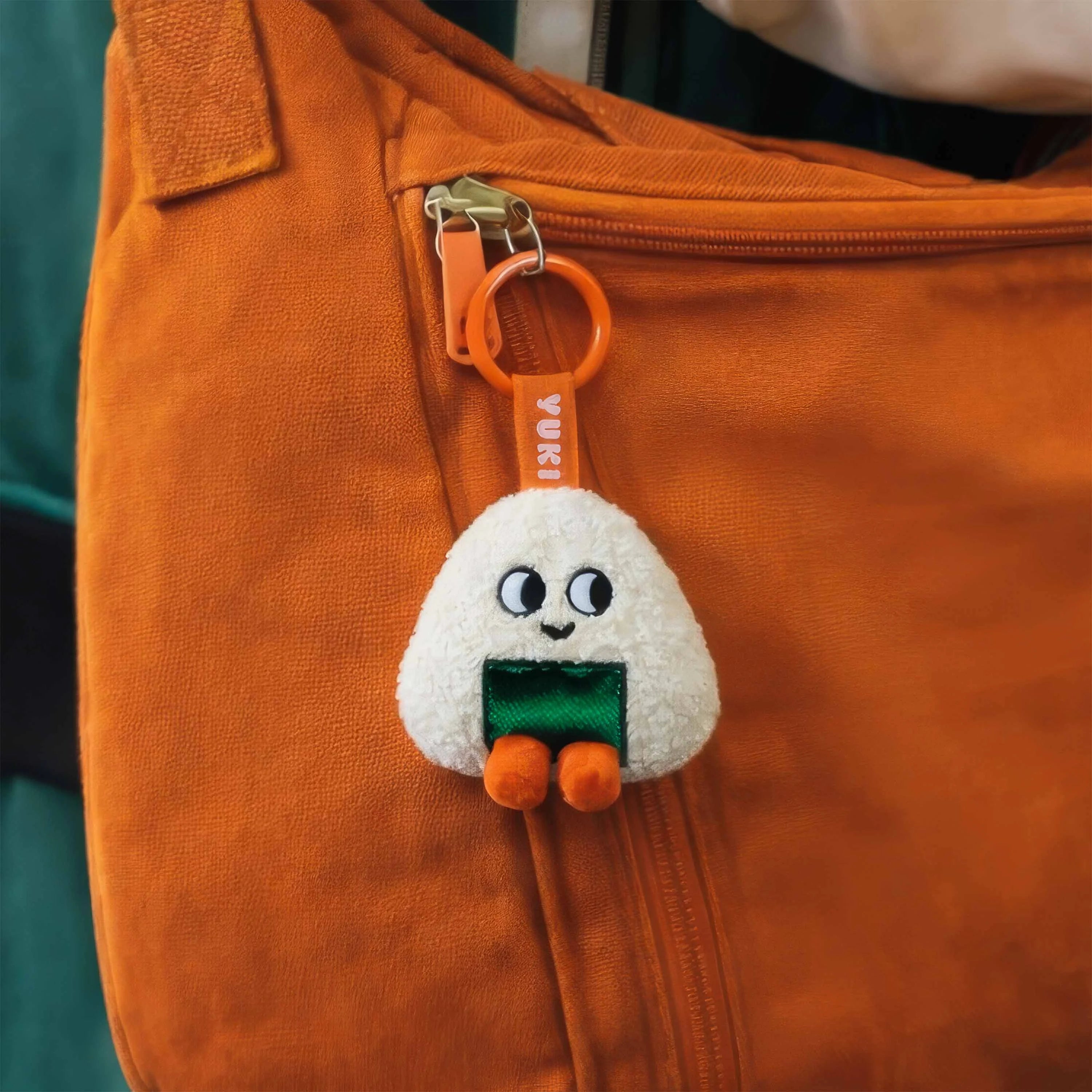 Mini peluche porte-clés Yuki accrochée à un sac orange