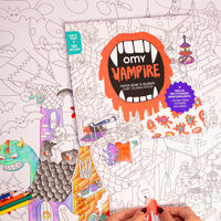 Enfant coloriant le poster géant Vampire OMY avec des crayons de couleur