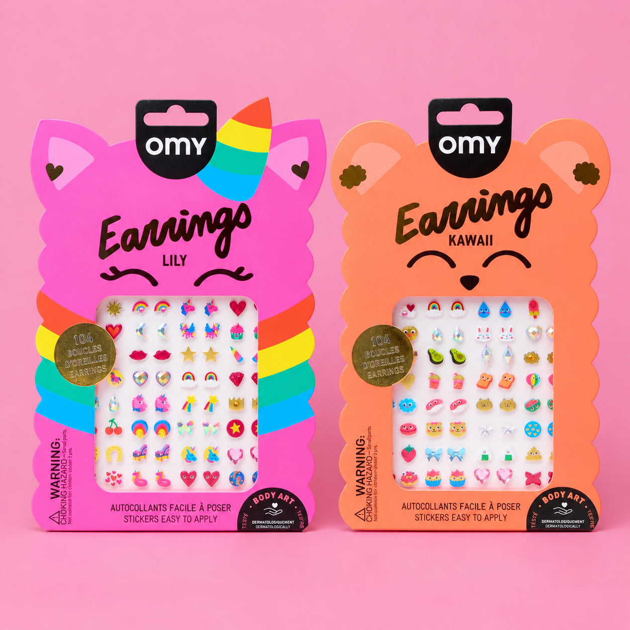 Duo de packs de boucles d'oreilles autocollantes OMY Earrings : Lily, chat licorne rose arc-en-ciel, et Kawaii, ourson orange, remplis de stickers d'oreilles colorés sur fond rose