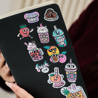 Stickers Bubble Tea holographiques OMY collés sur un carnet portable, motifs bubble tea, fruits et messages fun