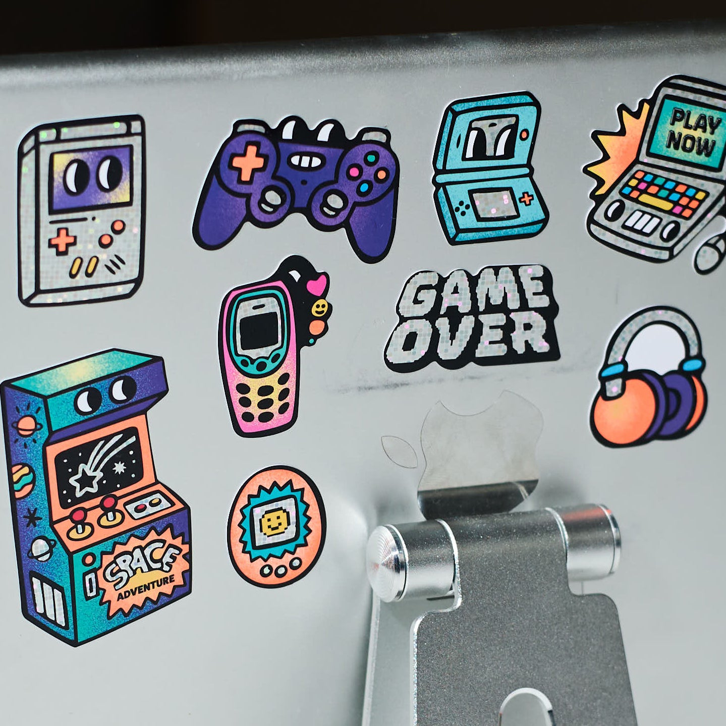 Détail des stickers Game Boy OMY holographiques avec consoles, manettes et texte Game Over