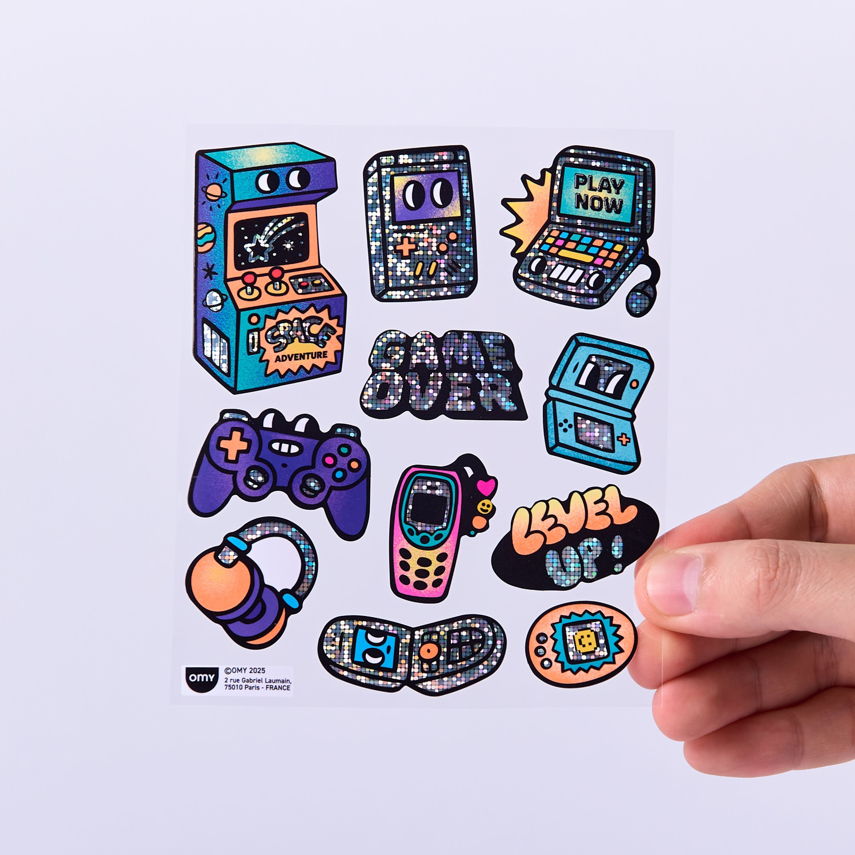 Planche de stickers Game Boy OMY avec consoles rétro, manettes, bornes d’arcade et messages pixelisés holographiques