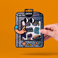 Packaging des stickers Game Boy OMY tenu en main, planche de stickers vinyle holographiques gaming