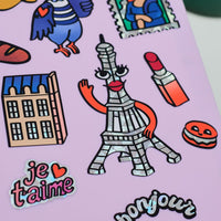 Détail sticker Tour Eiffel holographique avec visage illustré, bras et bouche rouge, issu de la collection Fabulous Stickers Paris.