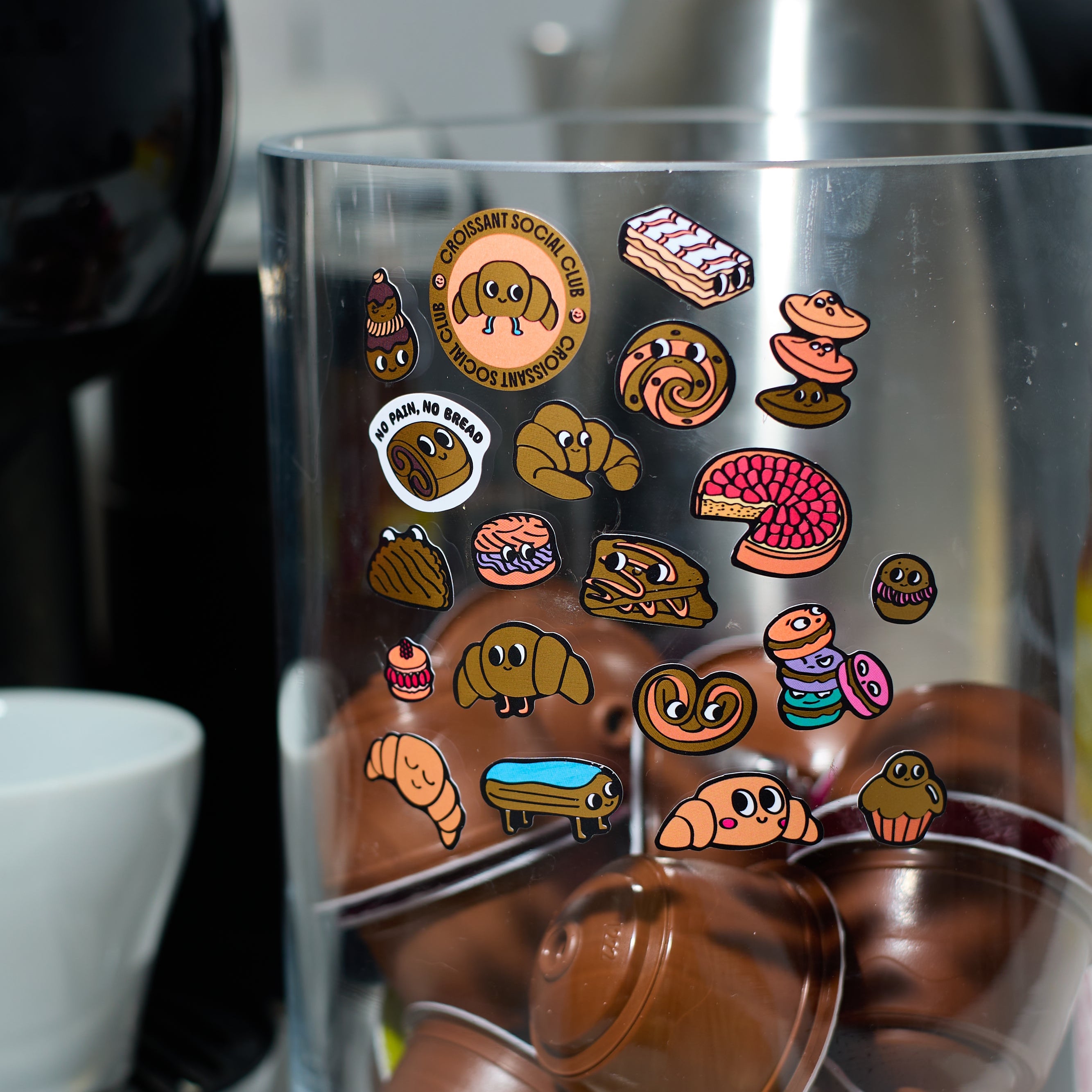 Stickers Croissant OMY décorant un récipient de cuisine, illustrations gourmandes de pâtisseries et viennoiseries.