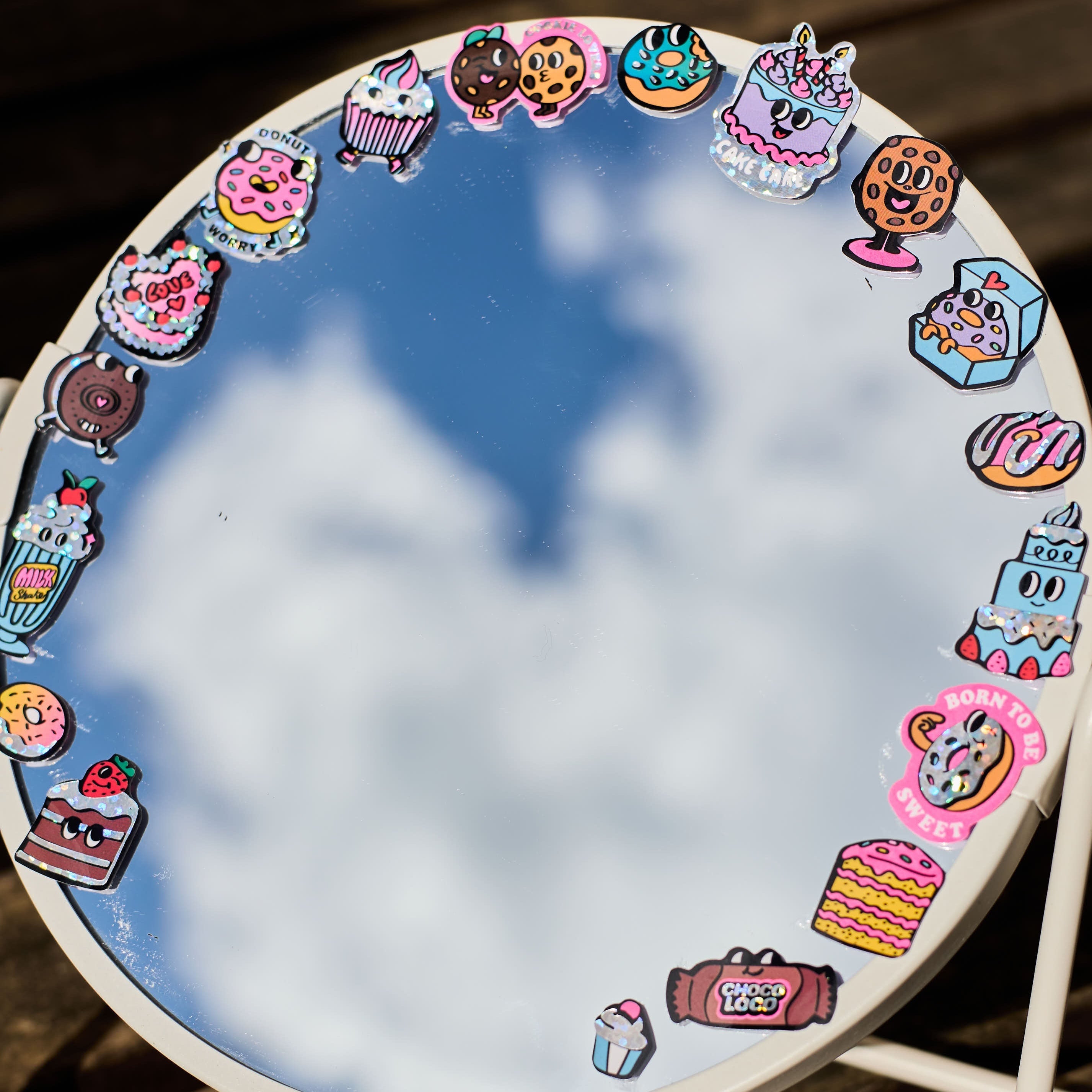 Holographic donut and pastry stickers by OMY stuck around a mirror, a colorful and gourmet decor
