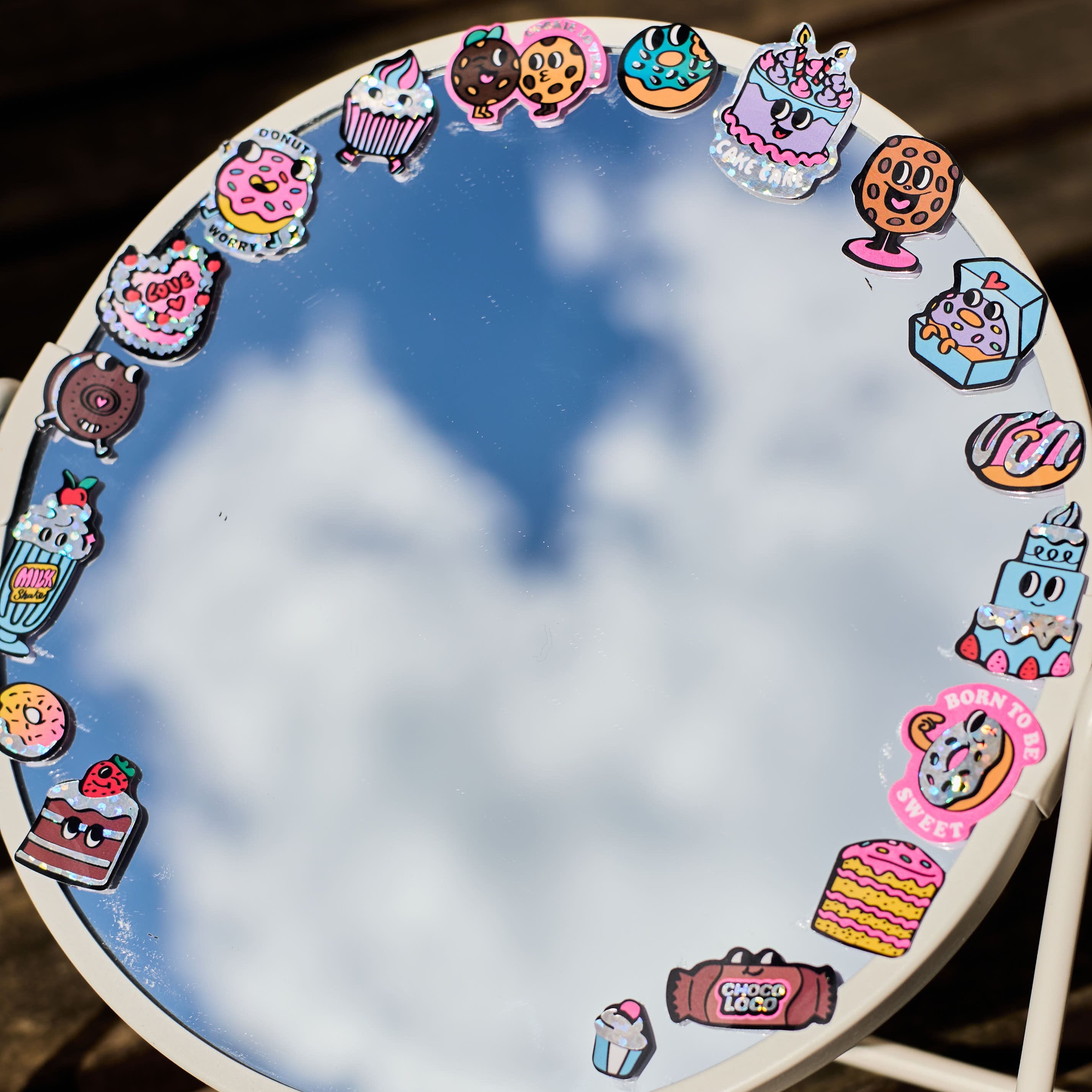 Stickers donuts et pâtisseries holographiques OMY collés autour d’un miroir, décor gourmand et coloré