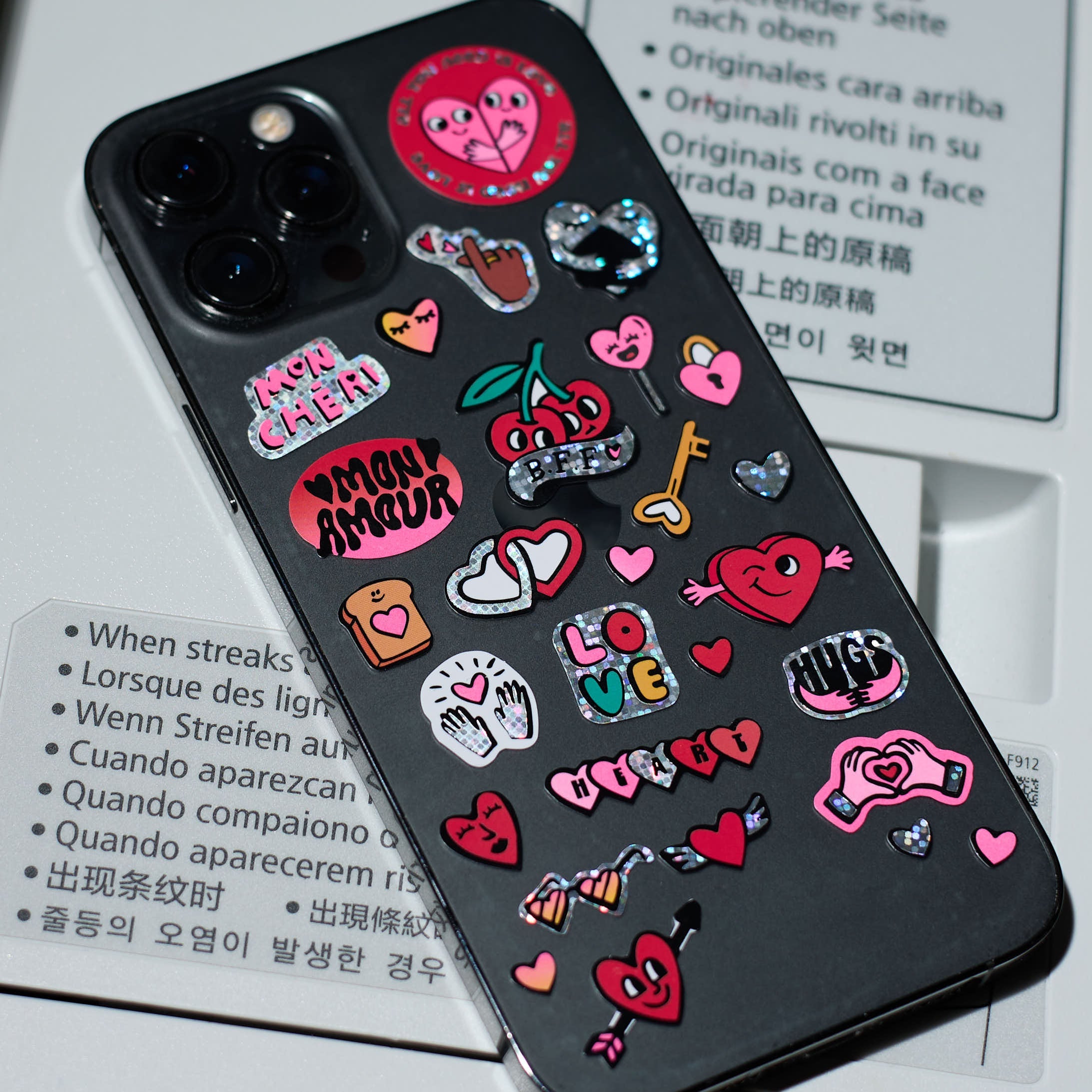 Back of an iPhone-style phone with Fabulous Stickers Iconic Love OMY, holographic vinyl sticker sheet with a love theme