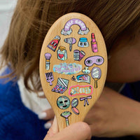 Stickers maquillage holographiques OMY collés sur une brosse à cheveux – rouges à lèvres, miroirs et accessoires beauté 