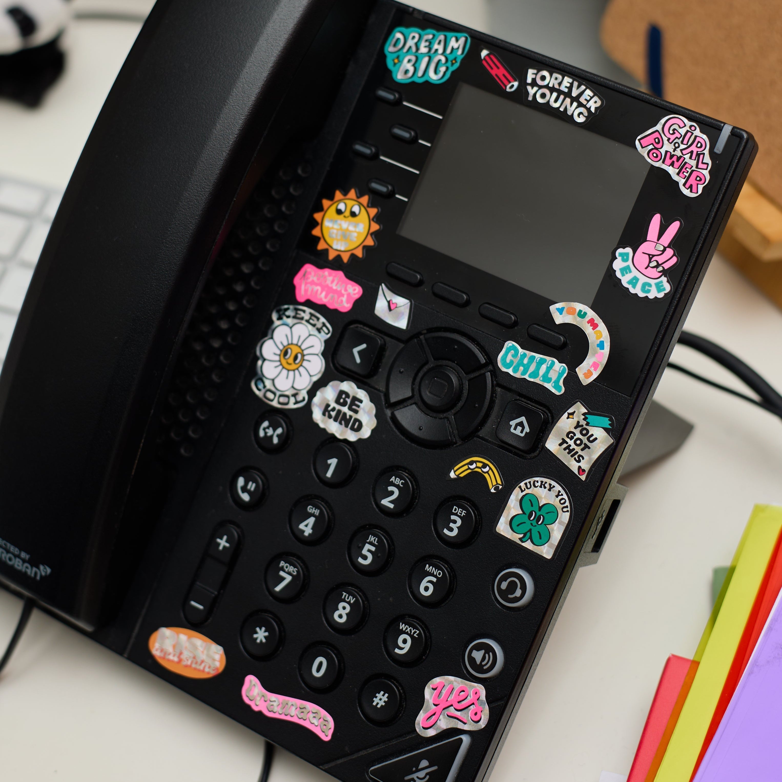 Positive-message vinyl stickers stuck on a landline phone, fun and inspiring OMY decor