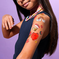 Fille avec tatouages temporaires OMY Kawaii – Motifs mignons, dorés et fluo sur la pea