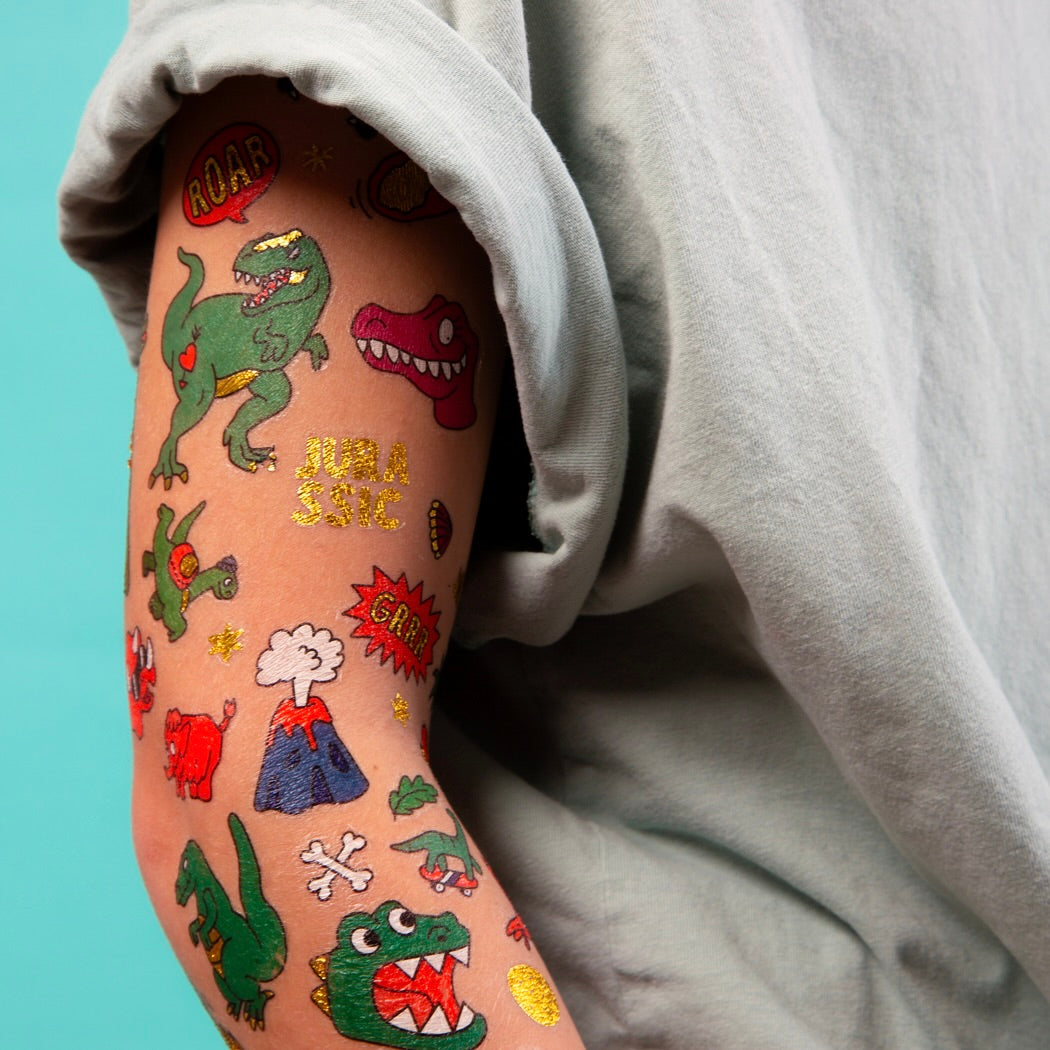 Tatouages temporaires Dinos OMY sur le bras d’un enfant – Motifs fluo, dorés et colorés 