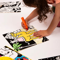 Little girl coloring a camel in front of the pyramids with an orange marker on a Velvet Coloring Animals OMY picture