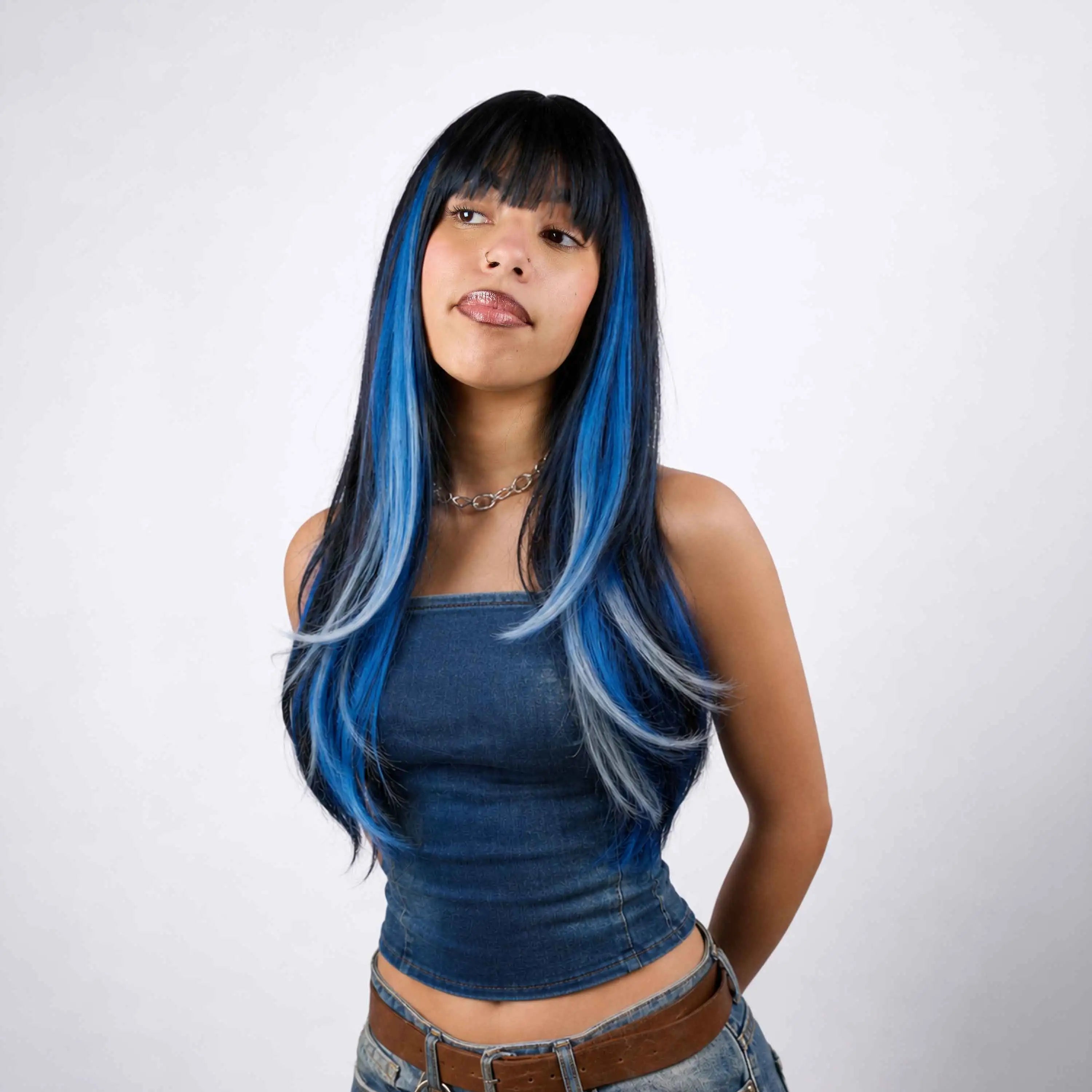 Jeune femme aux longs cheveux noirs avec des mèches bleues réalisées au Hair Chalk Wicked OMY – craie colorante temporaire pour cheveux, look audacieux et coloré