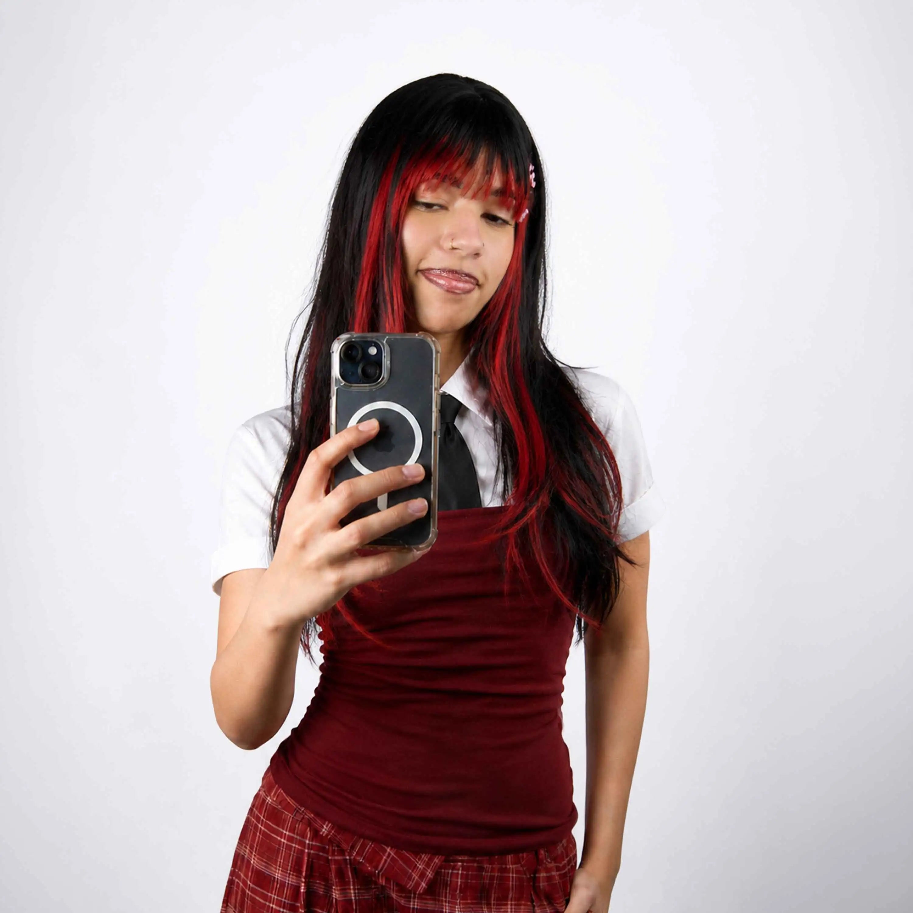 Jeune femme aux cheveux noirs avec des mèches rouges réalisées au Hair Chalk Wicked OMY – craie colorante temporaire pour cheveux, look rock et coloré
