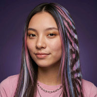 Femme aux cheveux longs bruns avec mèches colorées roses, bleues et violettes effet Wicked, coloration temporaire réalisée avec craies pour cheveux (hair chalk), style tendance et original