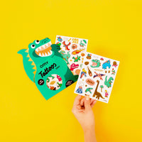  Main tenant les planches Tattoos Dinos OMY – 50 tatouages temporaires dinosaures pour enfants