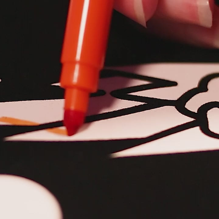 Vidéo en gros plan d'un feutre orange coloriant un tableau velours Velvet Coloring OMY