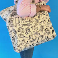 Vidéo du sac cabas Pop OMY à colorier, porté à l'épaule, illustré de motifs pop noir et blanc, sur fond bleu